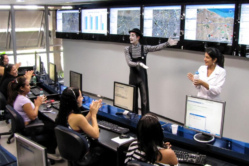 Palestrante SIPAT vestido de Charles Chaplin fazendo apresentação diante de profissionais de telemarketing