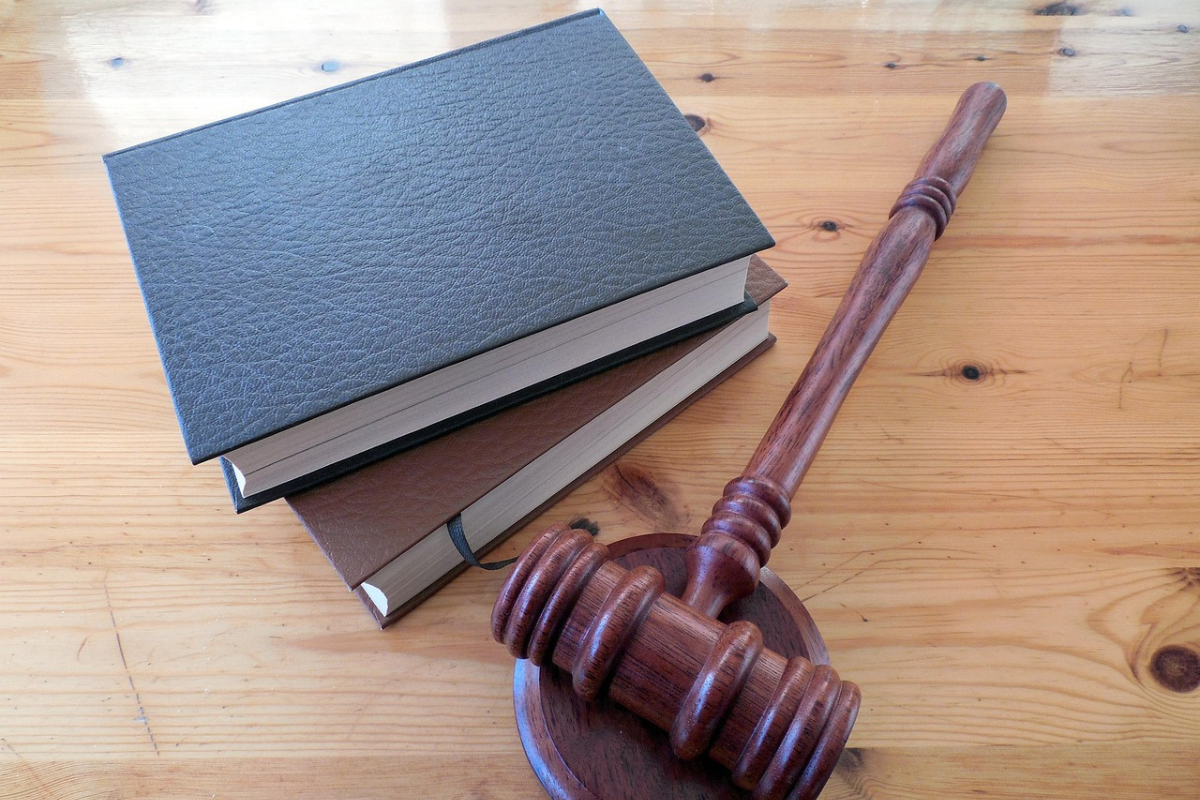 Mesa com martelo de juíz e cadernos