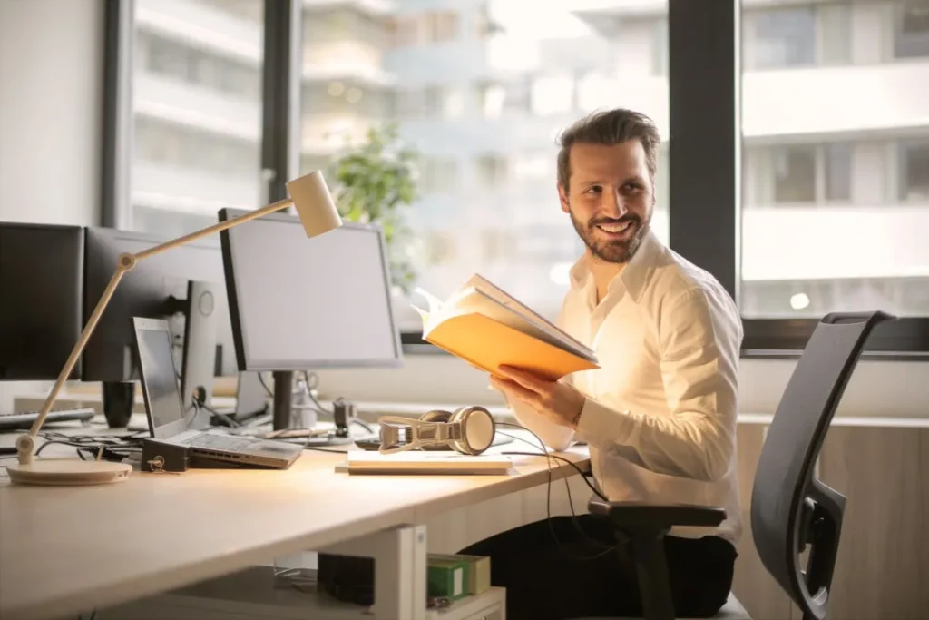 Homem em escritório, com caderno na mão