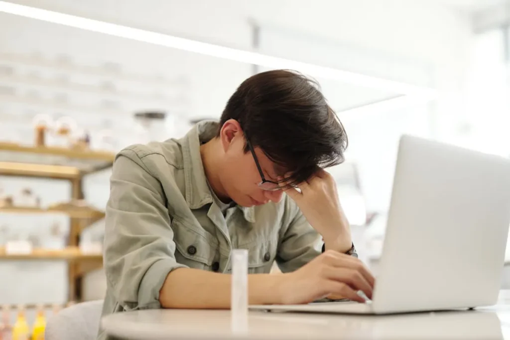 Homem cansado de frente para o laptop