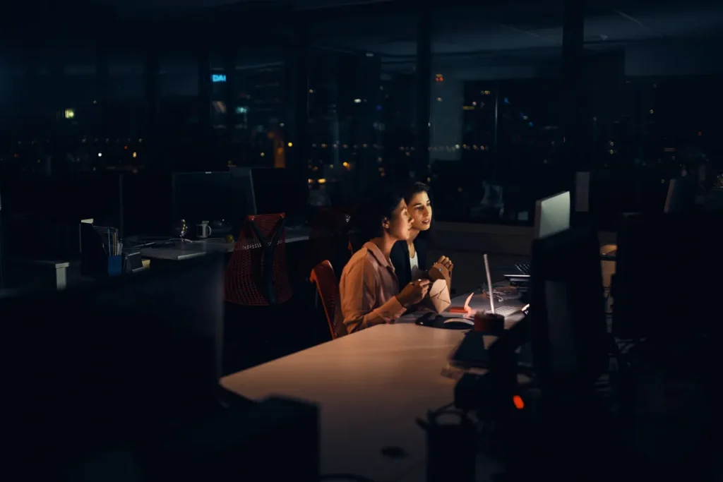 Pessoas trabalhando em escritório à noite.