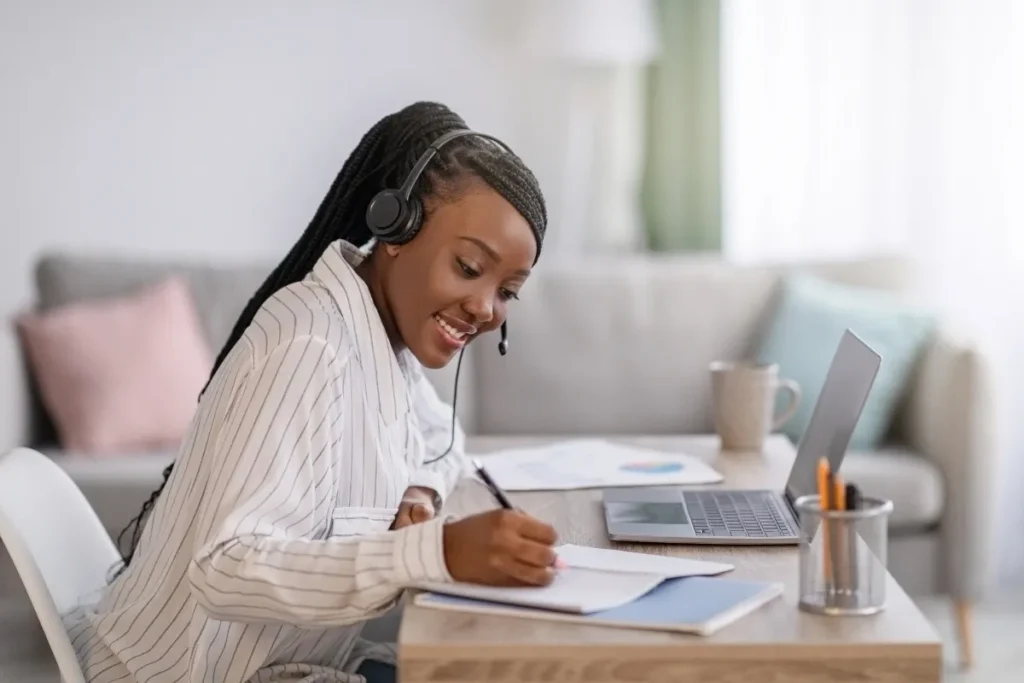 Mulher com headset e estudando pelo laptop