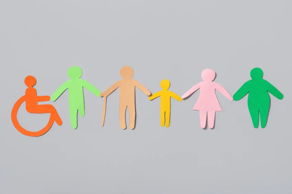Figuras coloridas representando diversidade, incluindo pessoa em cadeira de rodas e indivíduo com bengala