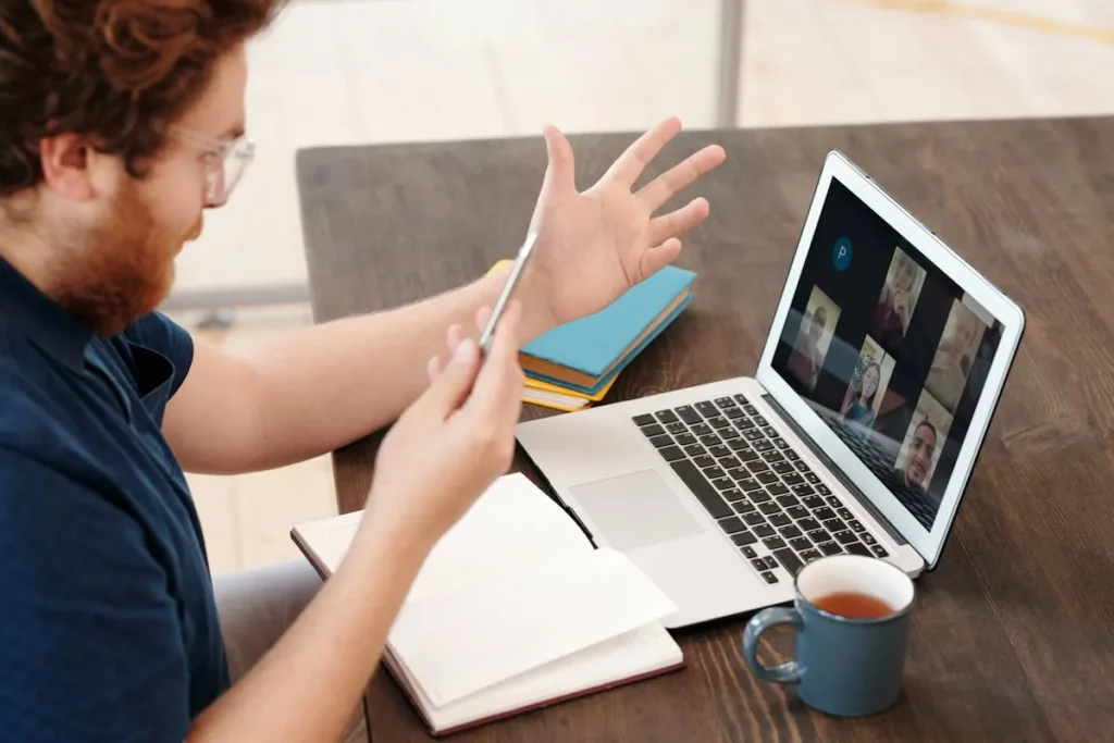 Colaborador participando de reunião em vídeo durante SIPAT online com interação ao vivo entre equipe e palestrante.