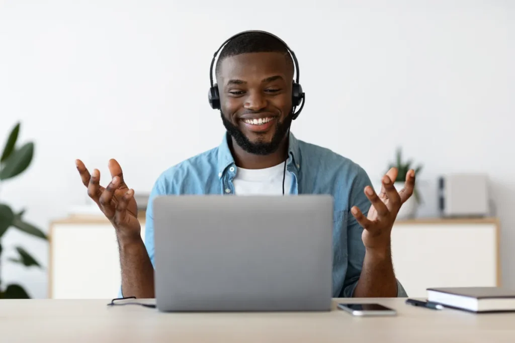 Colaborador sorrindo durante encontro virtual em notebook em atividade de SIPAT à distância na empresa.