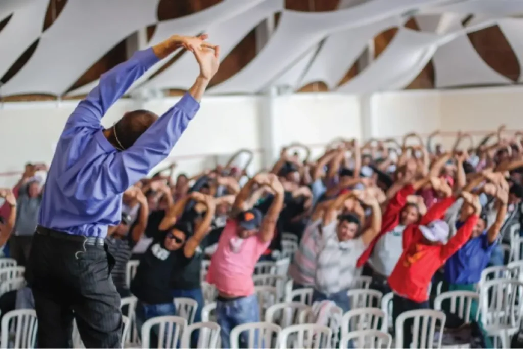 Colaboradores realizando alongamento coletivo durante SIPAT para empresa com foco em saúde ocupacional e prevenção.