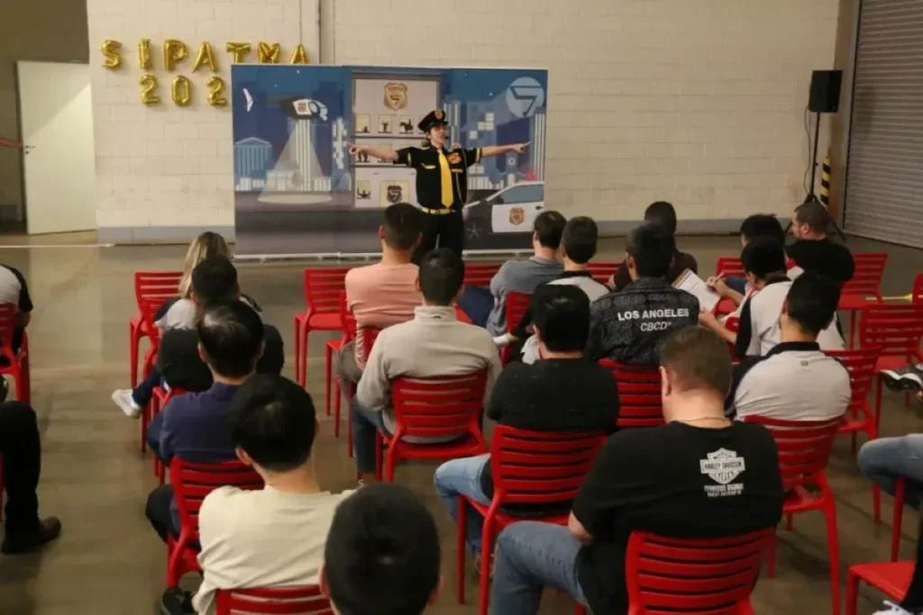 Apresentação temática durante SIPAT para empresa com equipe reunida em auditório acompanhando conteúdo de segurança.