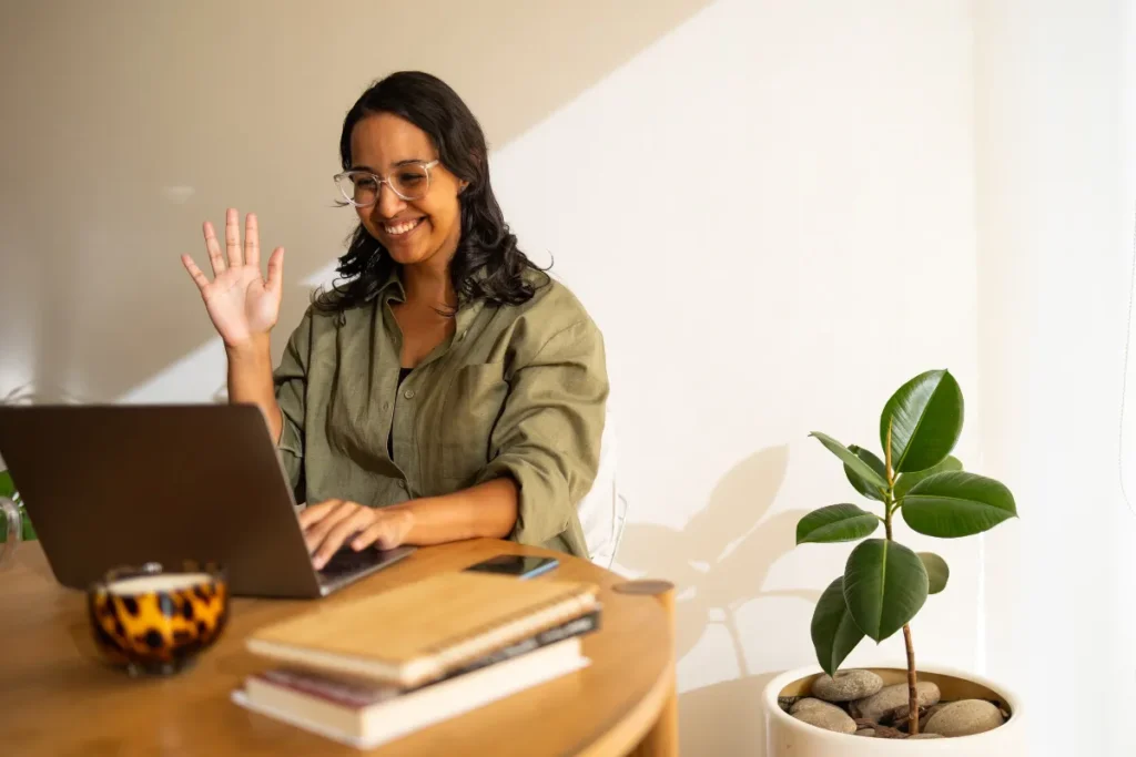 Colaboradora participando de SIPAT online para empresas em videochamada pelo notebook no ambiente de home office