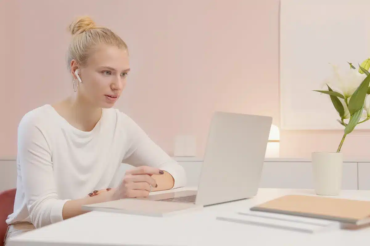 Profissional acompanhando SIPAT online pelo notebook em home office durante atividade remota de segurança do trabalho.