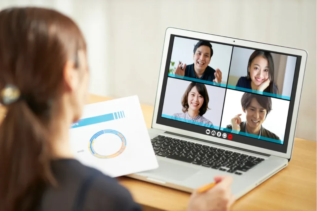 Colaboradora acompanhando apresentação virtual no notebook durante ação de SIPAT remota empresarial.