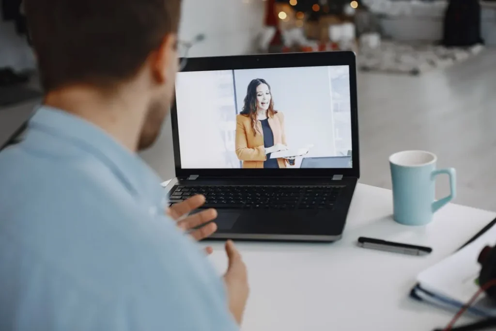 Colaborador assiste palestrante transmitindo conteúdo de segurança e saúde ocupacional por videoconferência.