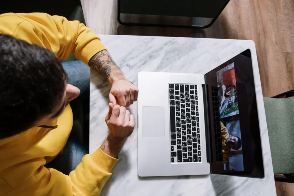Profissional acompanhando palestra corporativa online pelo notebook em ambiente residencial durante SIPAT.