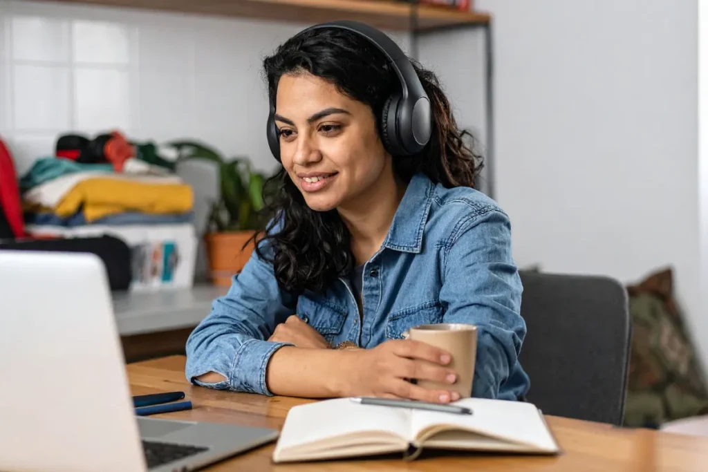 Mulher usando fones de ouvido enquanto acompanha treinamento online relacionado à segurança e saúde ocupacional.