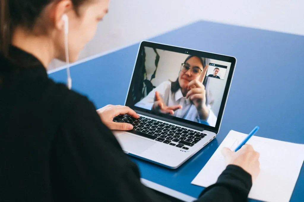 Profissional acompanha treinamento remoto e faz anotações durante palestra online da SIPAT corporativa.
