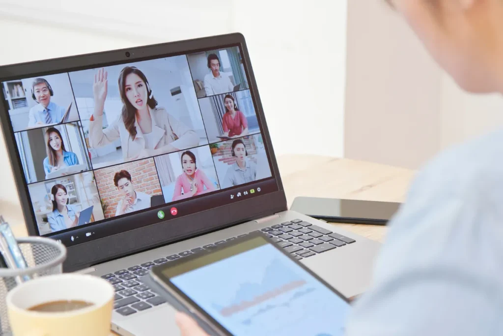 Tela de notebook exibindo videoconferência com diversos participantes em treinamento online sobre segurança ocupacional.