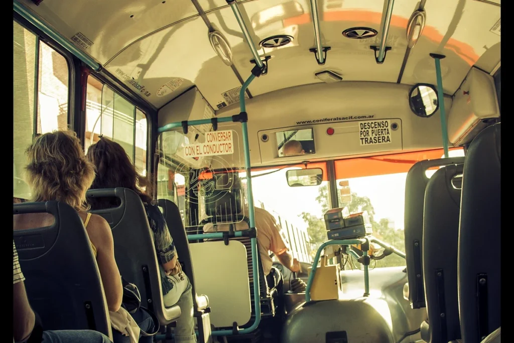 Passageiros sentados dentro de um ônibus urbano.