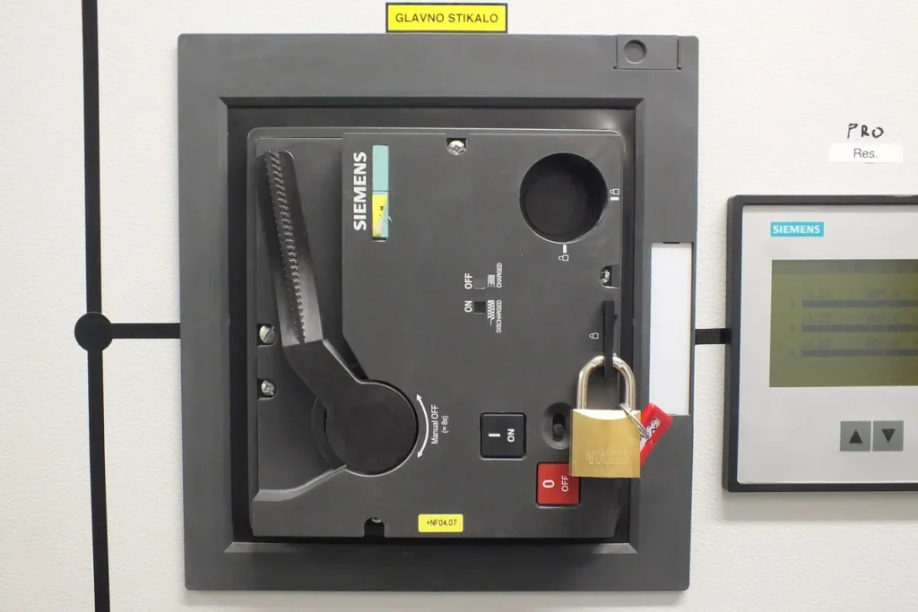 Chave geral de painel elétrico travada com cadeado e etiqueta vermelha de bloqueio