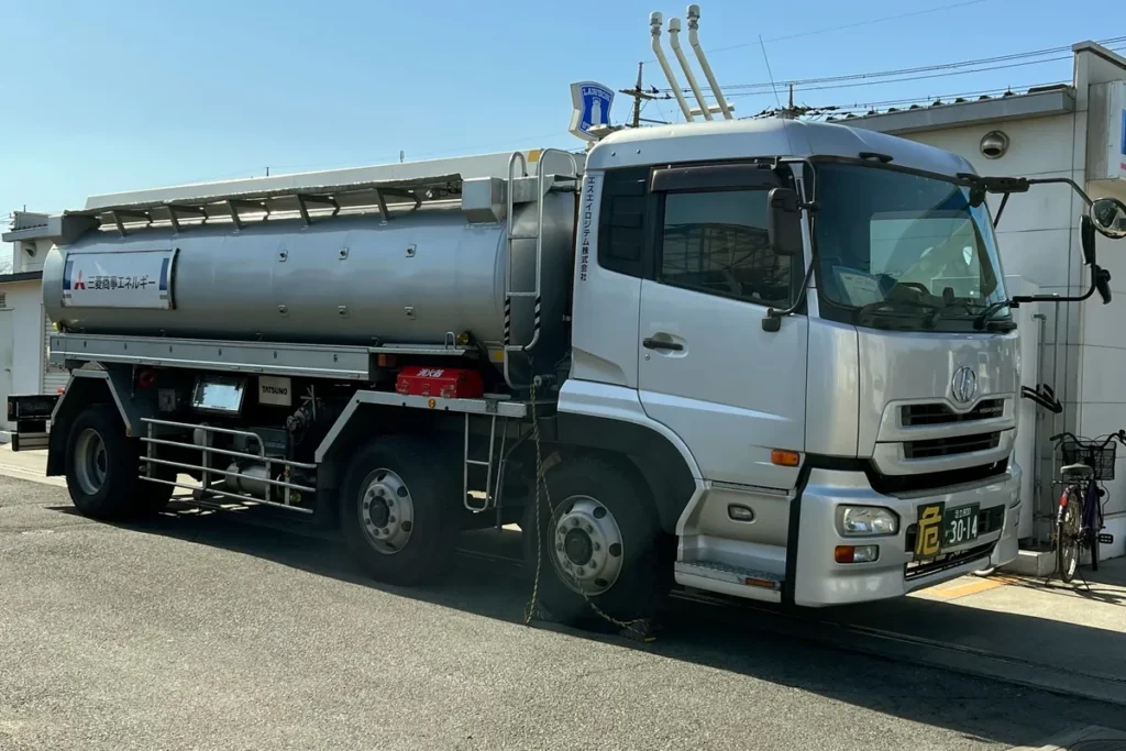 Caminhão-tanque prateado estacionado no pátio de uma área operacional