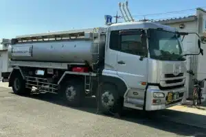 Caminhão-tanque prateado estacionado no pátio de uma área operacional