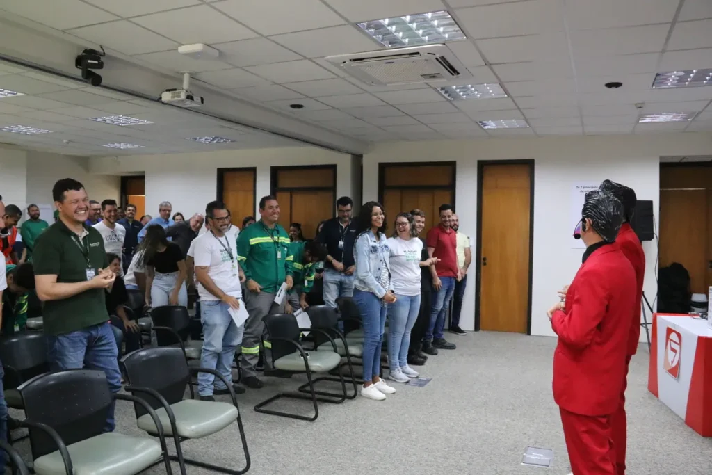 Palestrante de terno vermelho interagindo com público em evento de conscientização sobre o câncer de próstata.