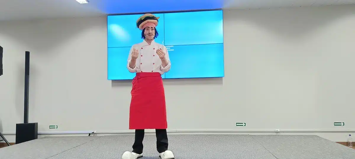 Apresentador caracterizado conduz pitch criativo em evento corporativo