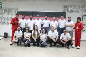Equipe organizadora da SIPAT 2025 posa para foto com palestrantes vestidos de vermelho após evento sobre saúde e segurança no trabalho