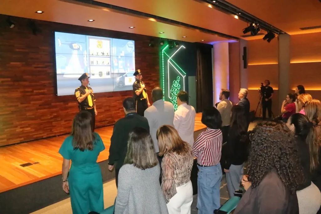 Palestrantes no palco interagem com o público em evento, contexto ideal para "frases motivacionais engraçadas".