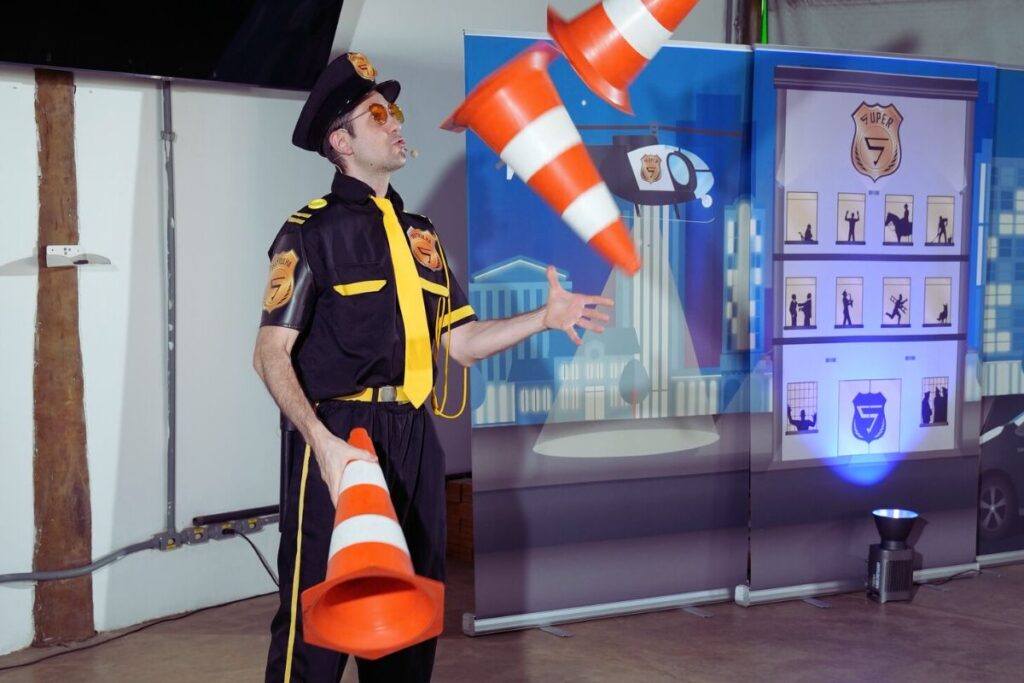 Instrutor uniformizado realiza dinâmica com cones de sinalização durante treinamento de percepção de risco em ambiente corporativo.