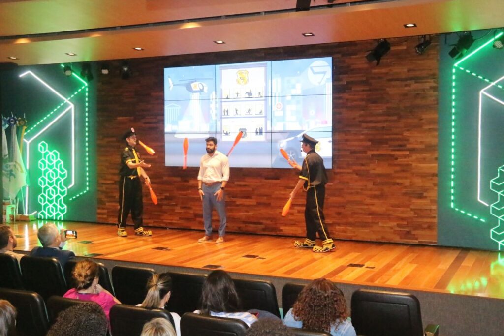 Palestrantes realizando dinâmica com malabares no palco durante palestra interativa para SIPAT.