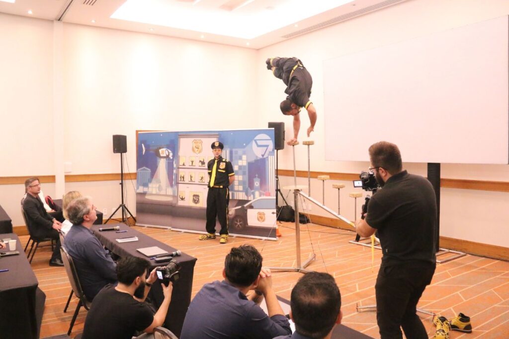 Artista realizando performance de equilíbrio durante gravação de palestra para SIPAT online com público assistindo.