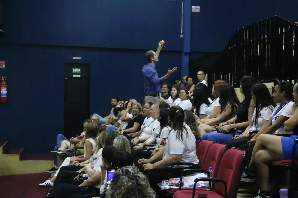 Palestrante interage com público em evento corporativo promovendo momentos de relaxamento e bem-estar